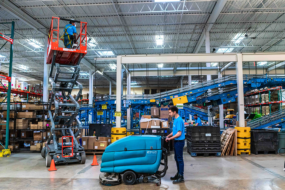 Warehouse floor cleaning crew at work
